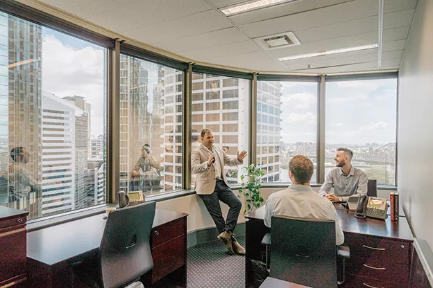 A team meeting in a modern Servcorp office with panoramic views, boost productivity in a professional workspace.